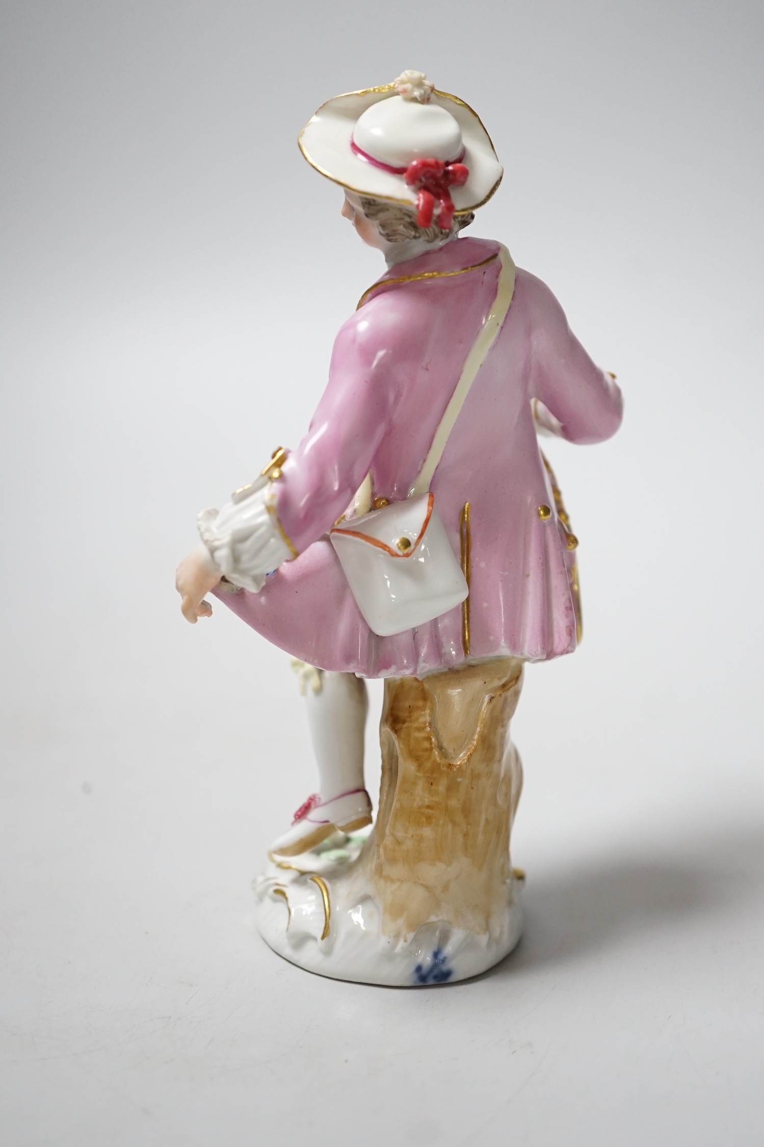 A Meissen figure of a young man with walking stick and his tail full of flowers, late 18th century, blue crossed swords to back of base
